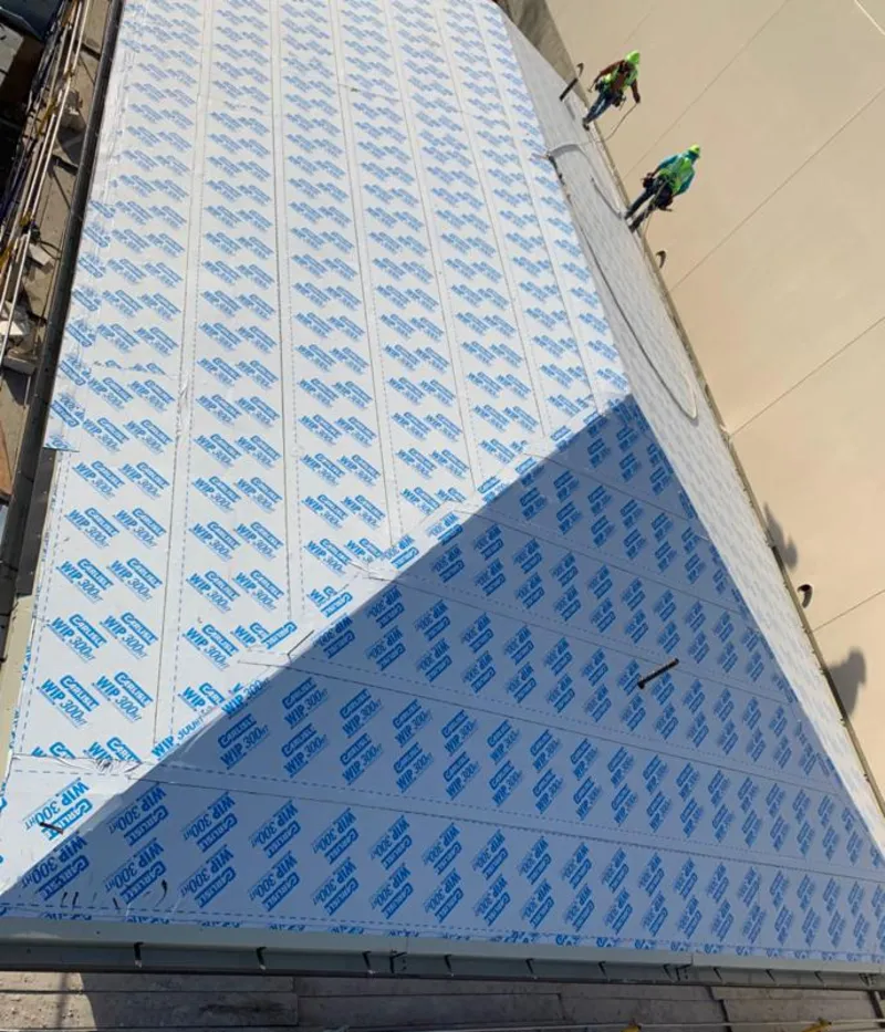 Professional roofers installing underlayment on a metal roof in Glenville